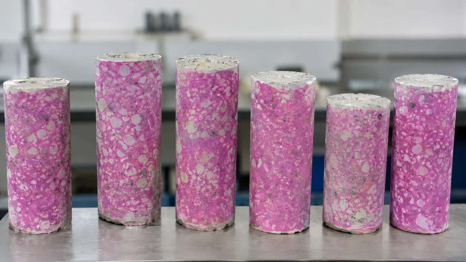 Sezione trasversale di campione di calcestruzzo con fronte di carbonatazione visibile dopo test alla fenolftaleina