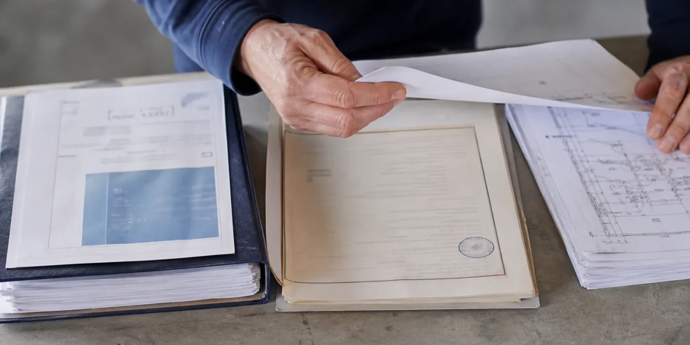 Documenti tecnici di un edificio a confronto su una scrivania